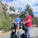 Two men ride Segways past a snow covered mountain